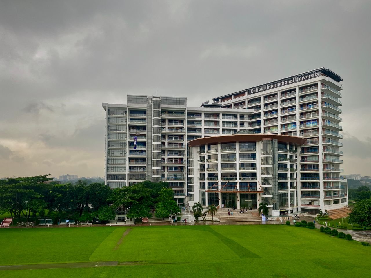 services-01 Modern architectural view of Daffodil International University with lush green surroundings in Dhaka.