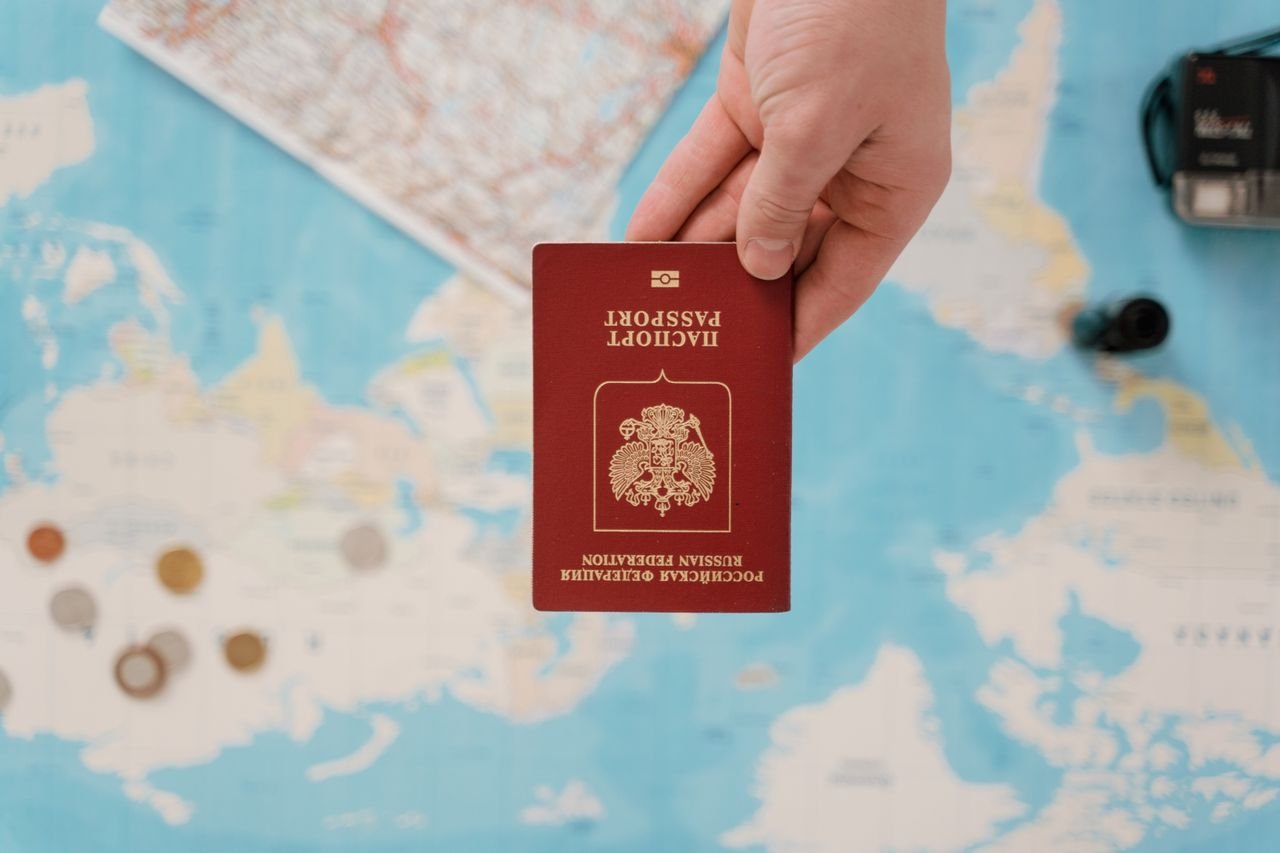 services-img A hand holding a Russian passport above a travel-themed map, capturing world travel concepts.