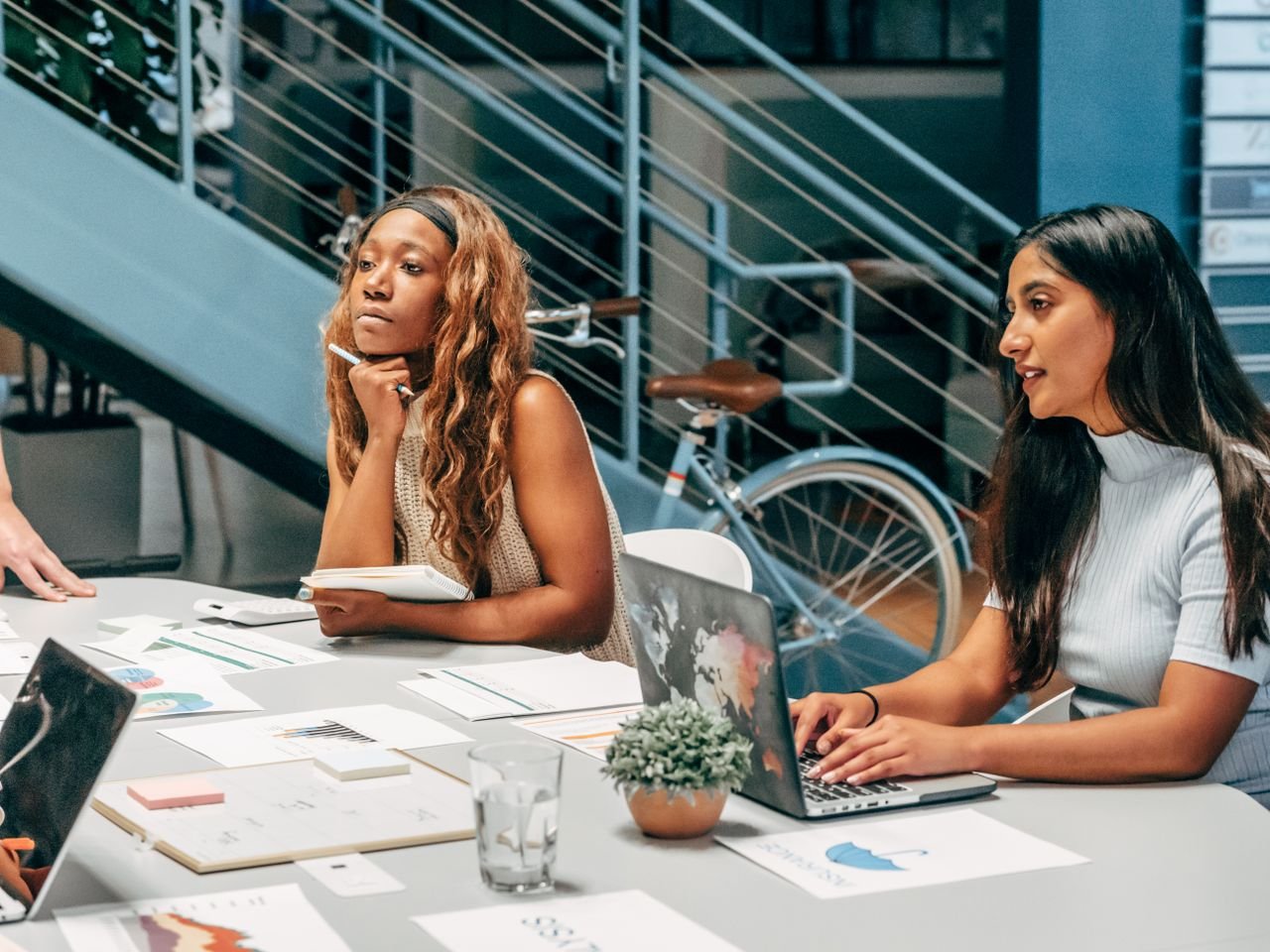 Mastering the First Impression: Your intriguing post title goes here Diverse women engaging in a collaborative meeting at an office desk, focused on planning and innovation.