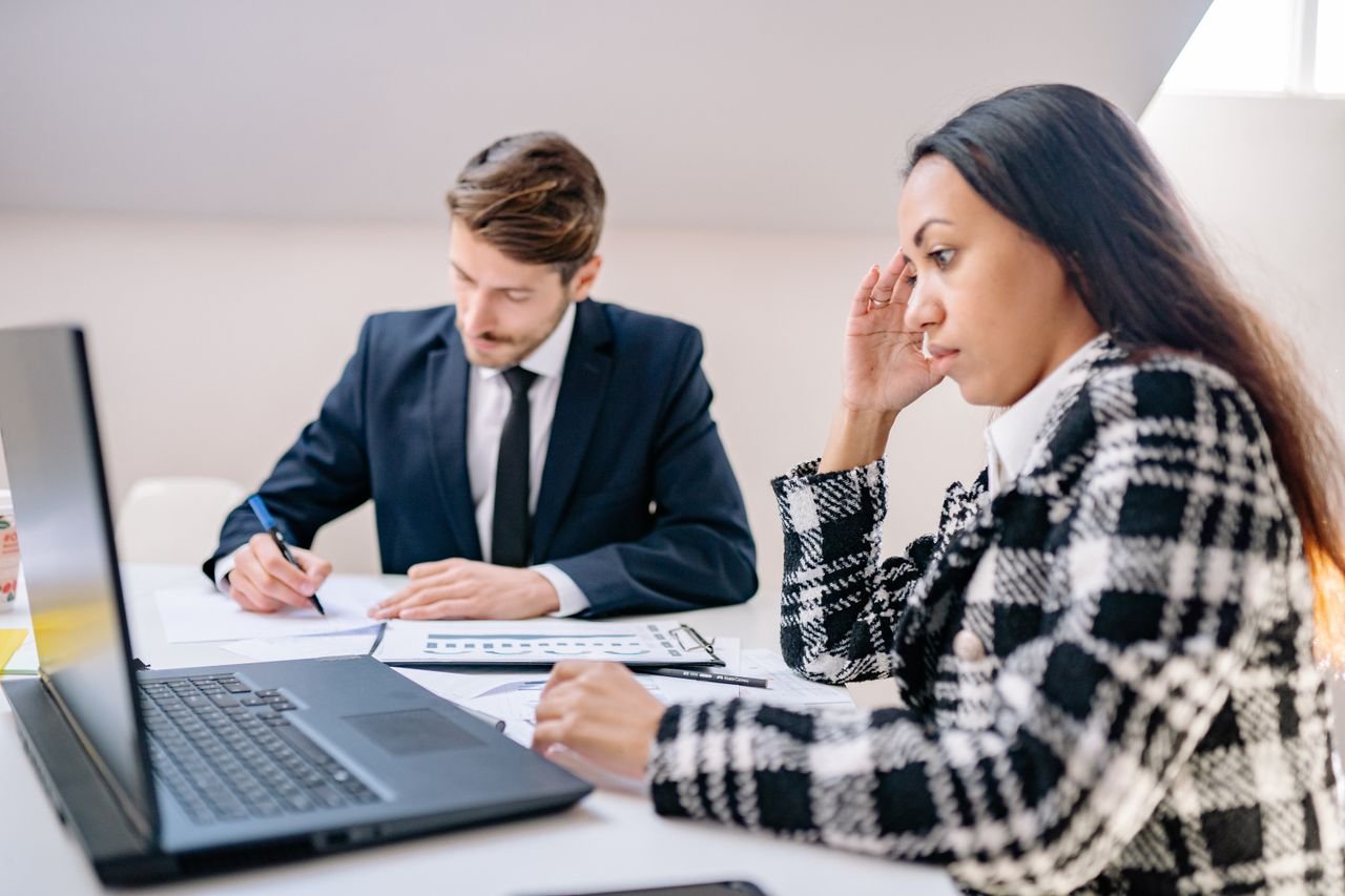 contact-img Two business professionals working together in an office, focusing on a project.