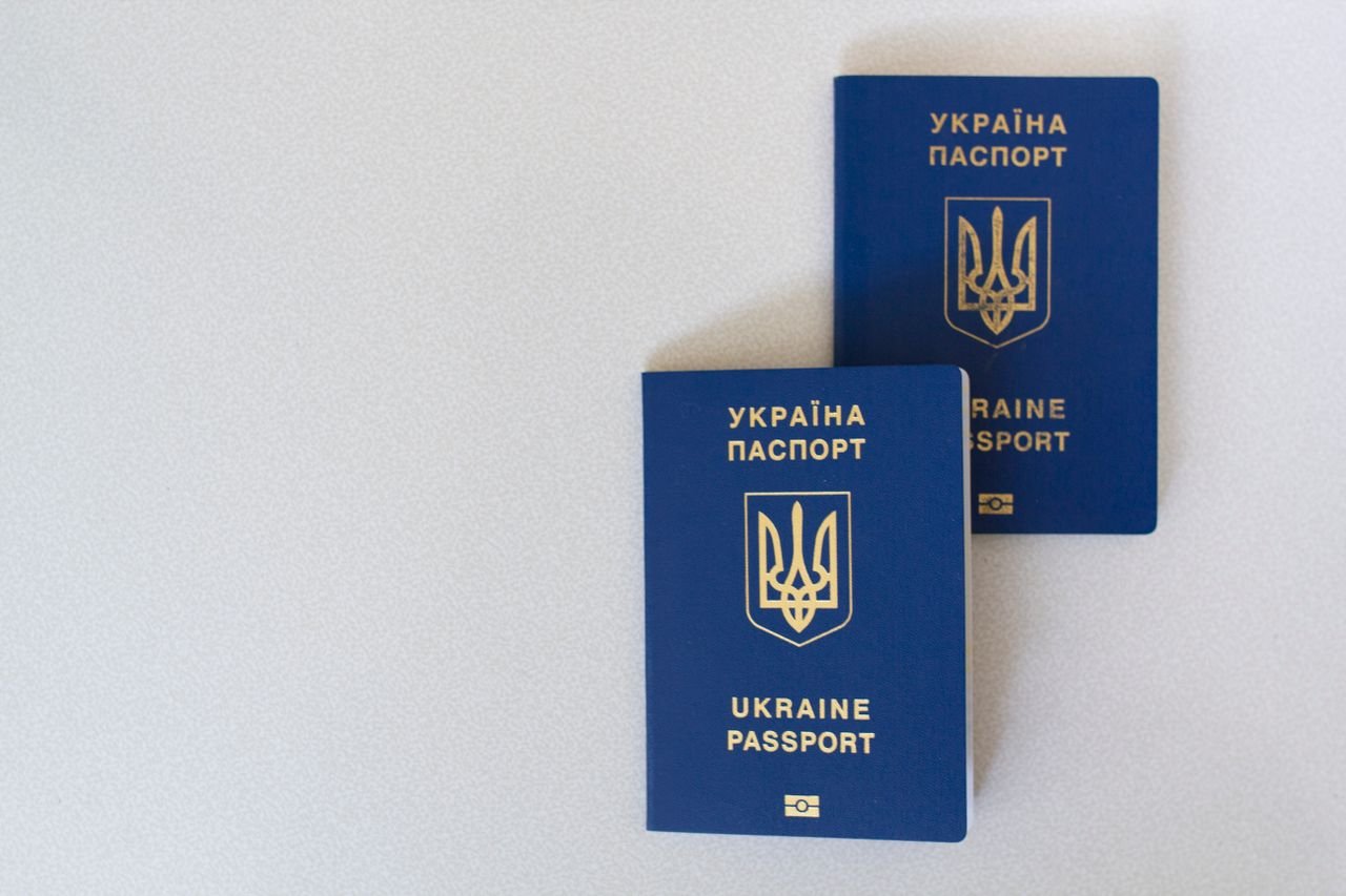 services-01 Two blue Ukrainian passports placed on a white surface, close-up view.